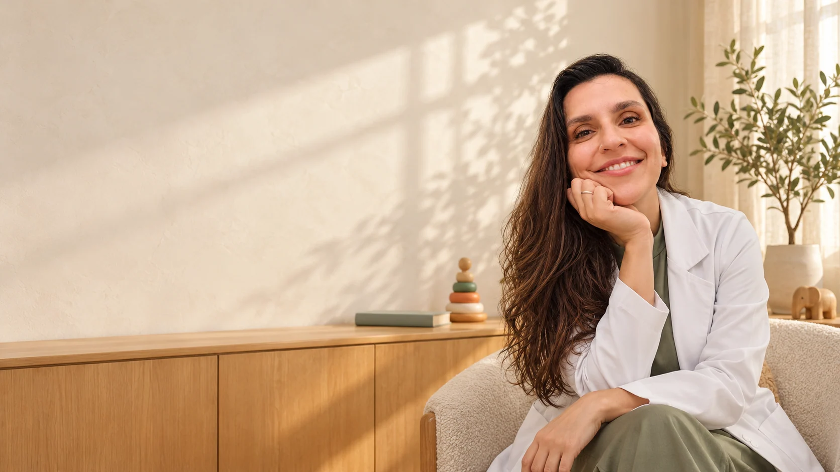 Dra. Gabi Chefaly, sorrindo em um ambiente acolhedor com luz natural.